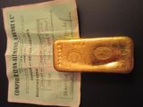un lingot d'or posé sur une feuille de papier