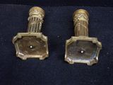pair of antique brass candlesticks on a black background