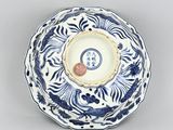 blue and white plate with a coin in the middle of it