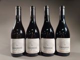 three bottles of red wine are lined up on a table