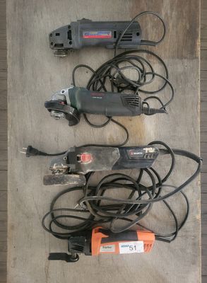 Trois outils électriques sont posés sur une surface en bois.