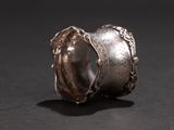 a close up of a silver ring on a black surface