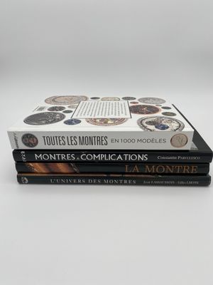 trois livres empilés sur une surface blanche