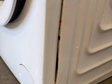 a white washing machine sitting on the floor in a room