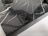 a close up of a marble table with a vase on top of it