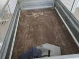 a metal cage with a mattress in it and a blanket on the floor