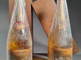 deux bouteilles de vin posées l'une à côté de l'autre sur une table
