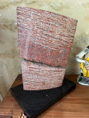 a statue of a man sitting on top of a table next to a statue of a woman