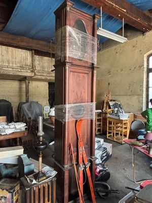 a room with a grandfather clock and many other items in it