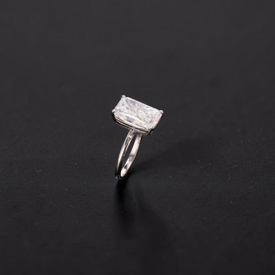 a white gold ring with a square cut diamond on a black background