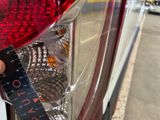a close up of a person measuring the tail light of a car
