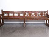 un banc en bois posé dans une pièce, avec un mur derrière lui