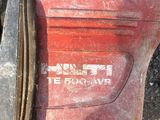 a close up of a red and black machine on the ground