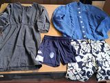 two pairs of clothes sitting on a table next to each other