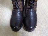 a close up of a pair of brown boots on a wooden floor