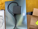 un ordinateur portable posé sur une table, avec son chargeur