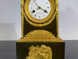 une horloge en or posée sur une table noire