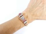 someone is wearing a bracelet with pink and white stones on it