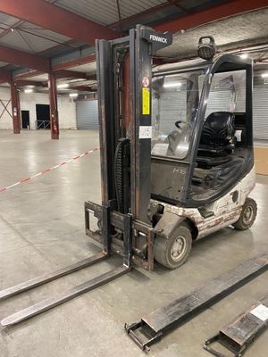 un chariot élévateur garé dans la zone de l'entrepôt