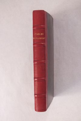 un livre rouge posé sur une surface blanche