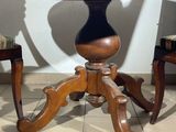 a wooden table with two chairs and a vase on it