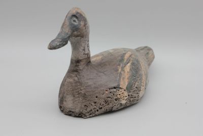un petit canard posé sur une surface blanche