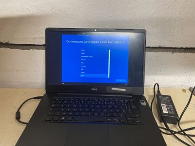 un ordinateur portable posé sur une table avec un chargeur