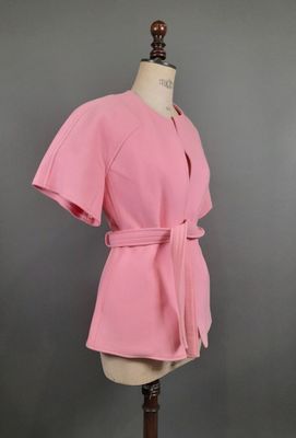 une robe rose sur un mannequin, sur fond noir