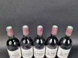 six bottles of wine are lined up in a row on a table