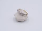 a close up of a diamond ring on a white surface