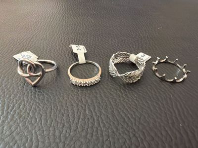 three rings and a key are sitting on a leather surface