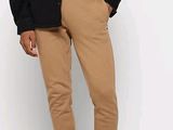 un homme debout, vêtu d'une veste et d'un pantalon