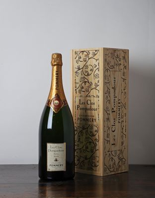 une bouteille de champagne posée à côté d'une boîte en bois sur une table