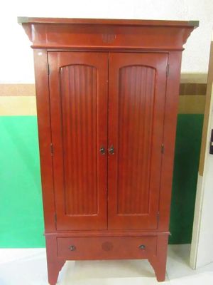 une armoire en bois à deux portes, avec un tiroir en dessous