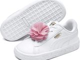 un gros plan sur une paire de chaussures blanches ornées d'une fleur sur la semelle