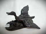 a statue of a duck that is sitting on top of a book
