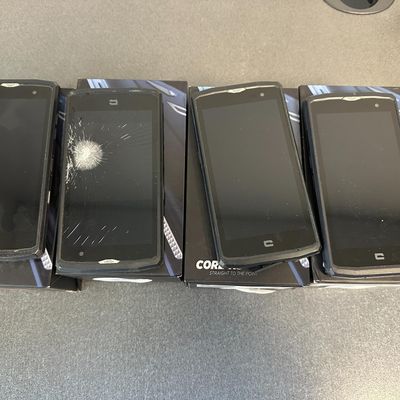 quatre téléphones portables sont posés en rang sur une table