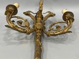 a gold plated chandelier with four arms and two candles