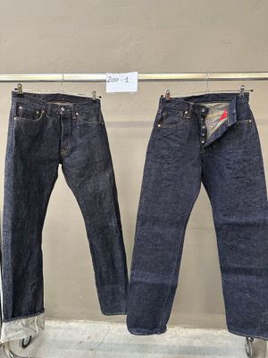 deux paires de jeans suspendues à un portant dans un magasin