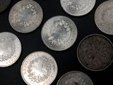 a lot of silver coins on a black surface
