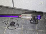 a vacuum that is sitting on the floor next to a charger