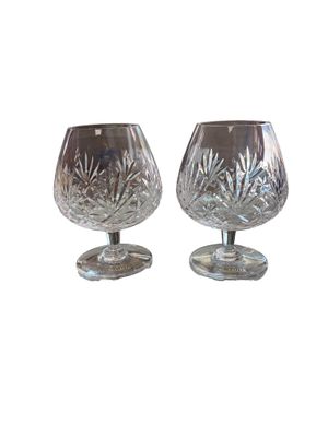 une paire de verres à pied en cristal sur un socle, sur fond blanc