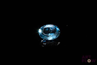 une image montrant un gros plan d'un diamant bleu sur une surface noire