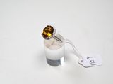 une bague sertie d'une citrine sur un fond blanc