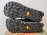 the soles of a pair of black hiking shoes on top of a cardboard box