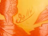 an orange vase with a picture of a woman on it