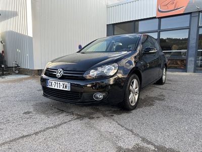 une Volkswagen Golf noire garée devant un immeuble