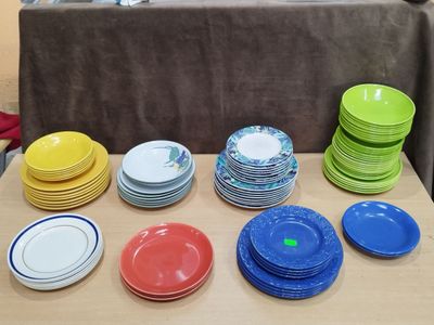 beaucoup d'assiettes colorées posées sur une table dans une pièce