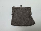 a close up of a metal purse on a white surface