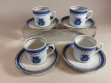 four blue and white cups and saucers sitting on a tray